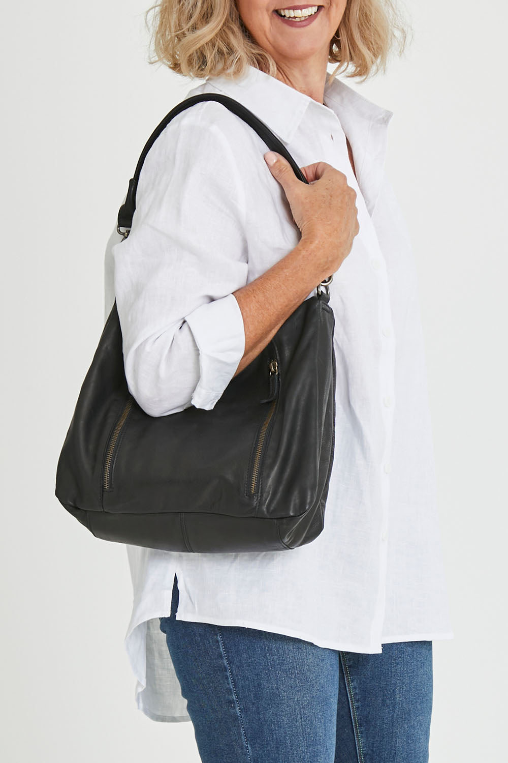 Model Sandy wearing size OneSize of the Poppy Leather Bag in colour Black (Black), from the front, cropped image