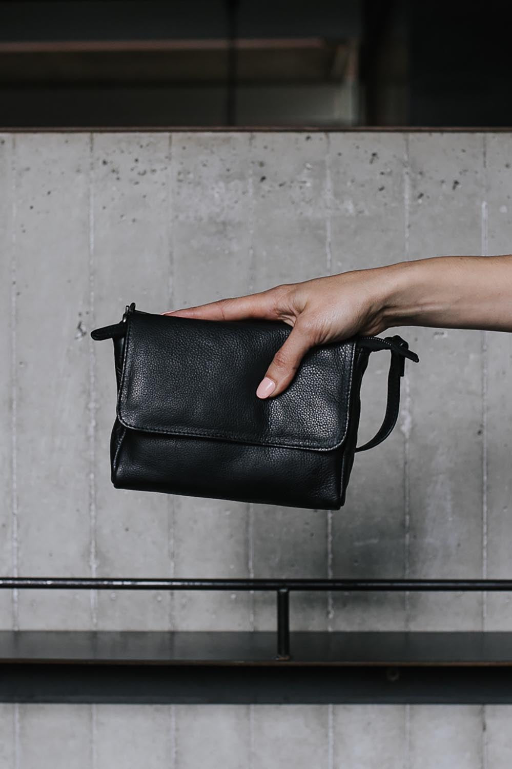 A model wearing the Sara Leather Bag in colour Black (Black), from the front, showing the whole outfit