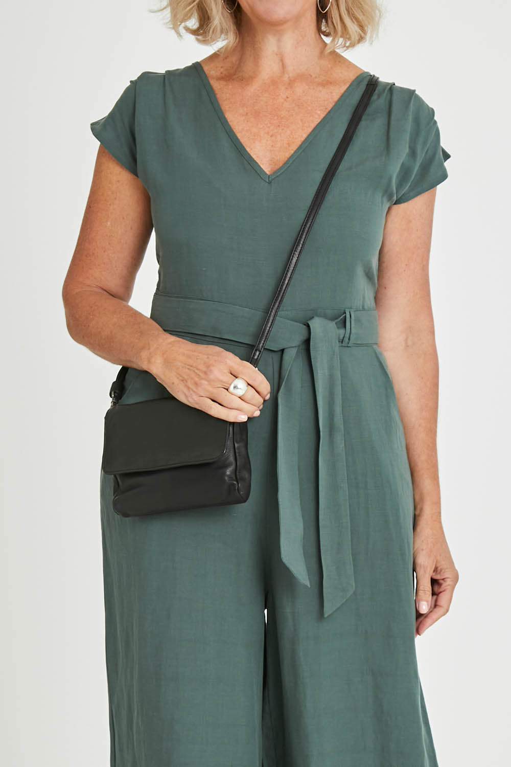 Model Sandy wearing size OneSize of the Sara Leather Bag in colour Black (Black), from the front, cropped image
