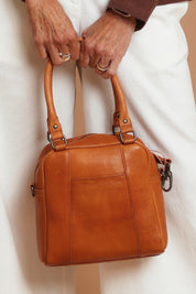 A model wearing the Suki Leather Multiway Bag in colour Tan, from the front, showing the whole outfit
