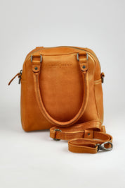 A model wearing the Suki Leather Multiway Bag in colour Tan, from the front, showing the whole outfit