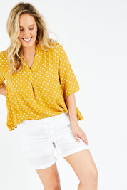 Model Jess wearing size L of the Masai Shorts in colour Salt (White), from the front, cropped image