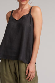 A model wearing the Studio Linen Tank in colour Ebony (Black), from the front, cropped image