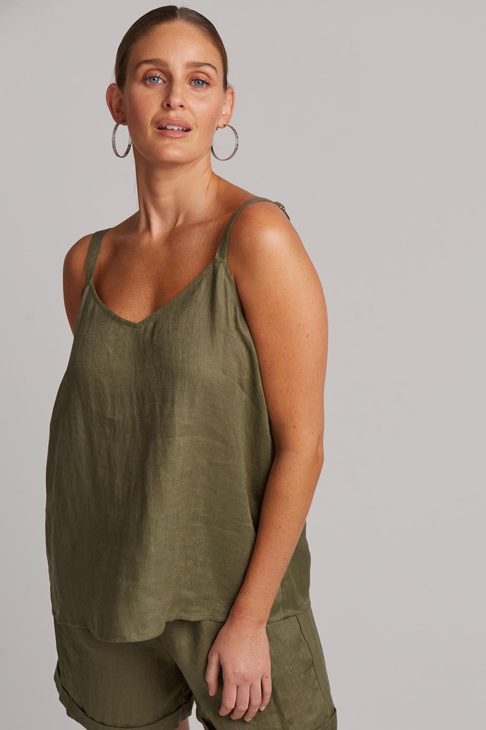 A model wearing the Studio Linen Tank in colour Khaki (Green), from the front, cropped image
