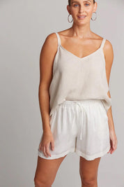 A model wearing the Studio Linen Short in colour Salt (White), from the front, showing the whole outfit