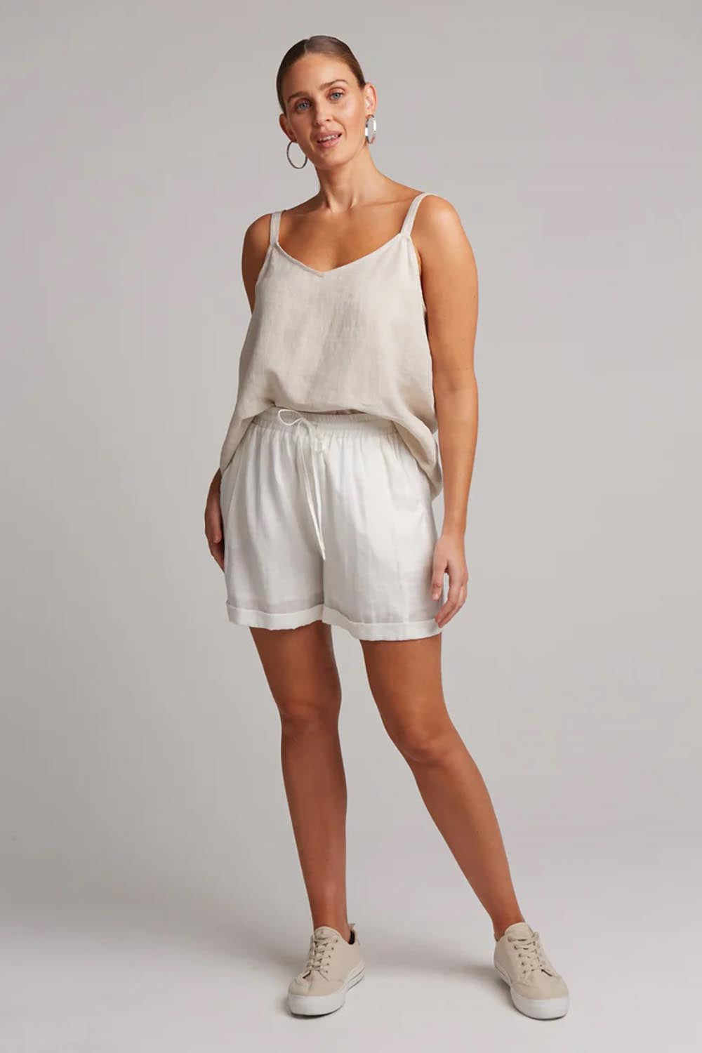 A model wearing the Studio Linen Short in colour Salt (White), from the front, showing the whole outfit