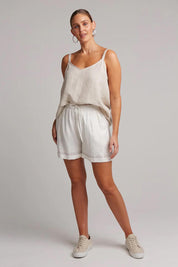 A model wearing the Studio Linen Short in colour Salt (White), from the front, showing the whole outfit