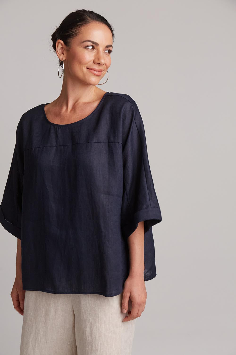 A model wearing the Studio Relaxed Top in colour Navy (Blue), from the front, cropped image