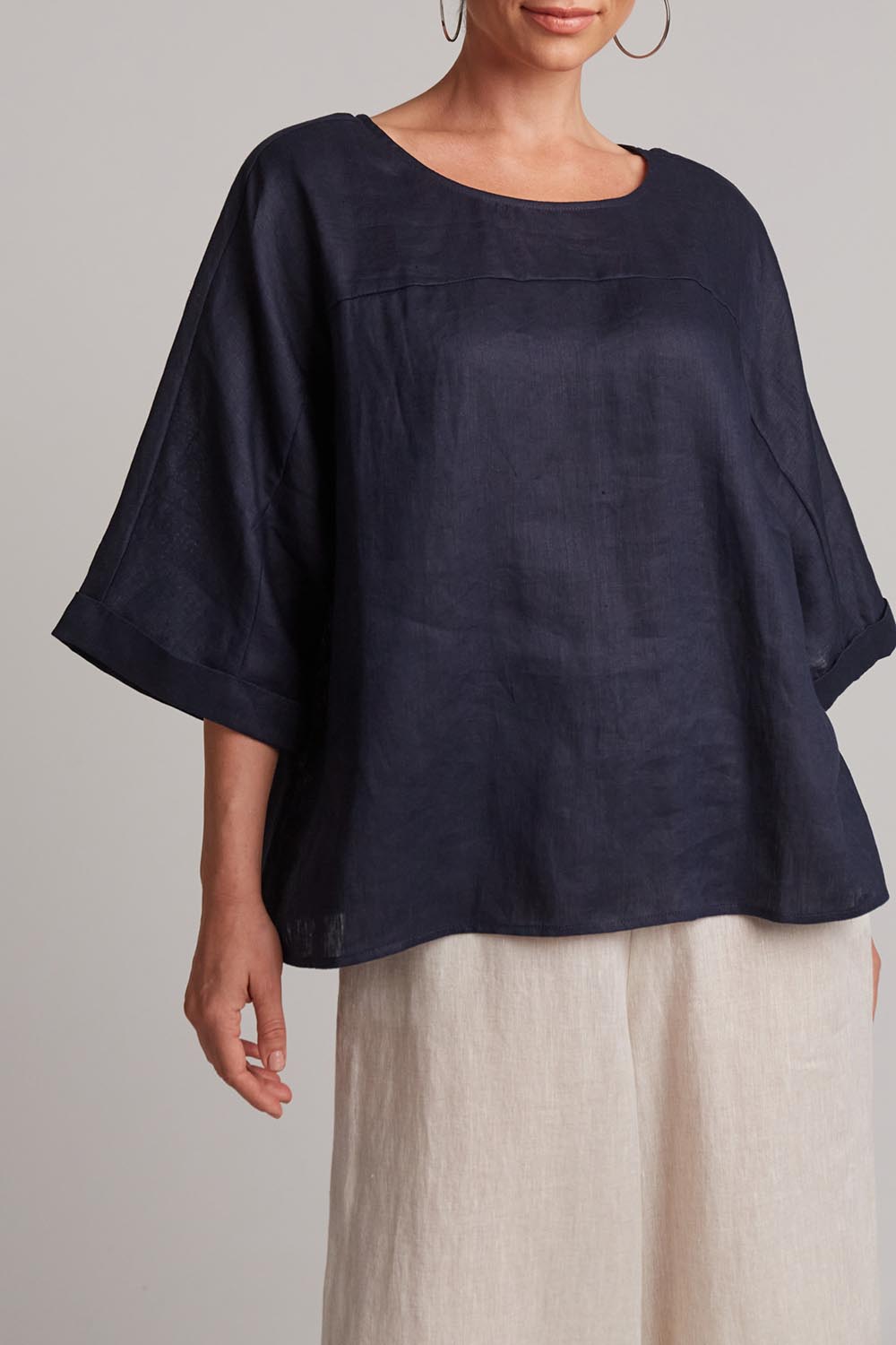 A model wearing the Studio Relaxed Top in colour Navy (Blue), from the front, cropped image