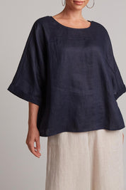 A model wearing the Studio Relaxed Top in colour Navy (Blue), from the front, cropped image