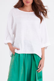 Model Madeline wearing size OneSize of the Studio Relaxed Top in colour Salt (White), from the front, cropped image