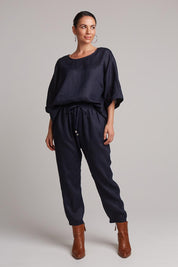 A model wearing the Studio Relaxed Linen Pant in colour Navy (Blue), from the front, showing the whole outfit