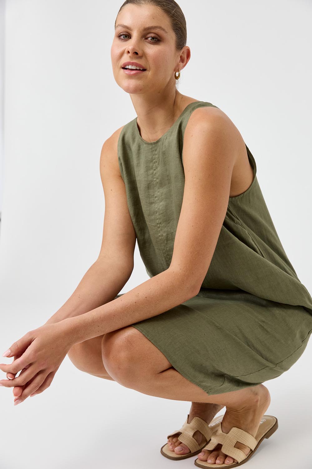 A model wearing the Studio Linen Midi Dress in colour Khaki (Green), from the front, showing the whole outfit
