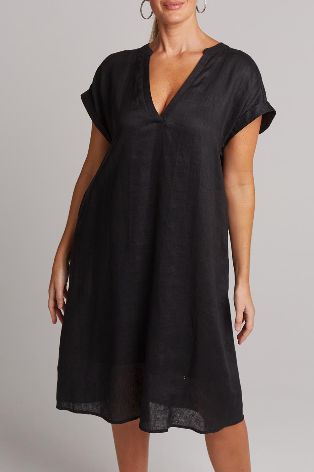 A model wearing the Studio Linen Dress in colour Ebony (Black), from the front, cropped image