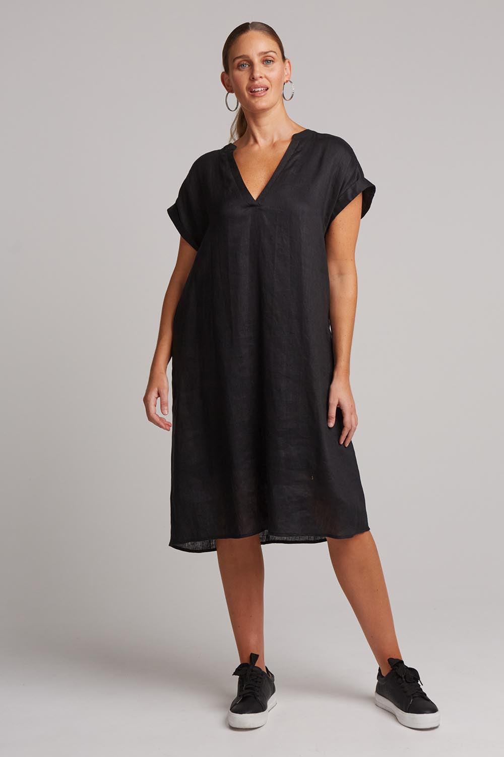 A model wearing the Studio Linen Dress in colour Ebony (Black), from the front, showing the whole outfit