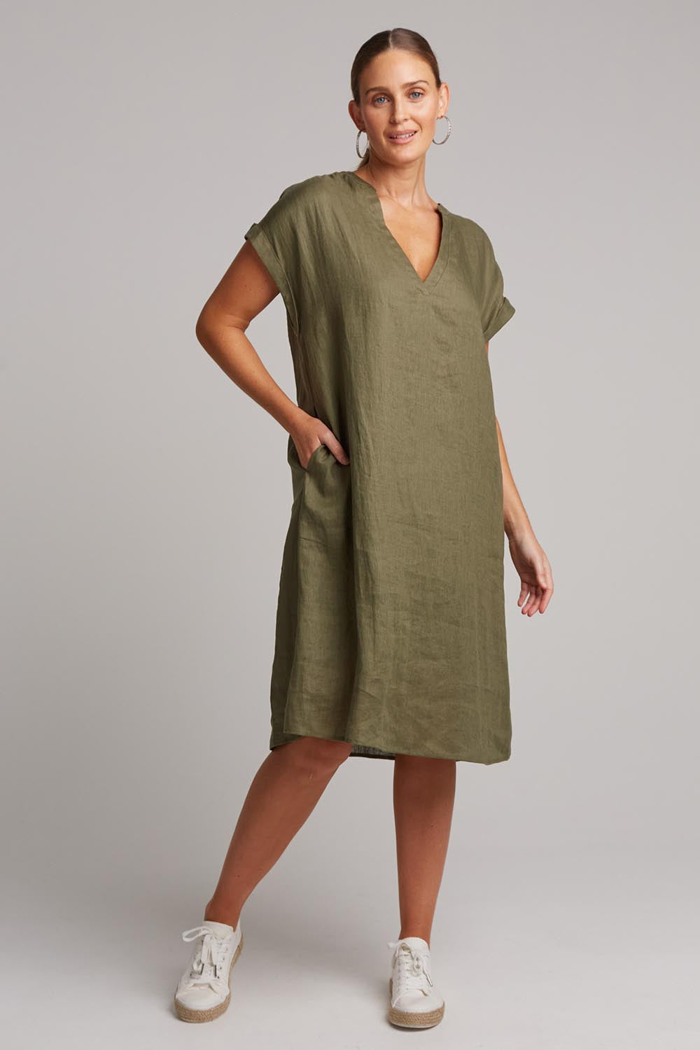 A model wearing the Studio Linen Dress in colour Khaki (Green), from the front, showing the whole outfit