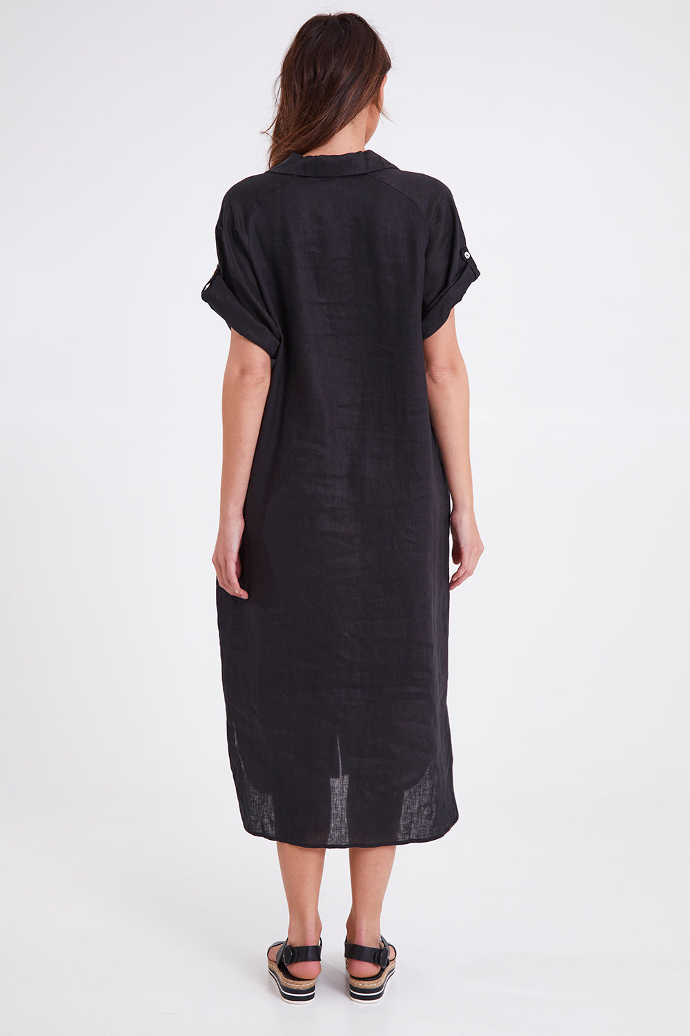Model Madeline wearing size S of the Studio Shirt Dress in colour Ebony (Black), from the back