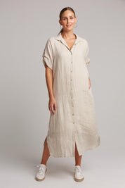 A model wearing the Studio Shirt Dress in colour Tusk, from the front, showing the whole outfit
