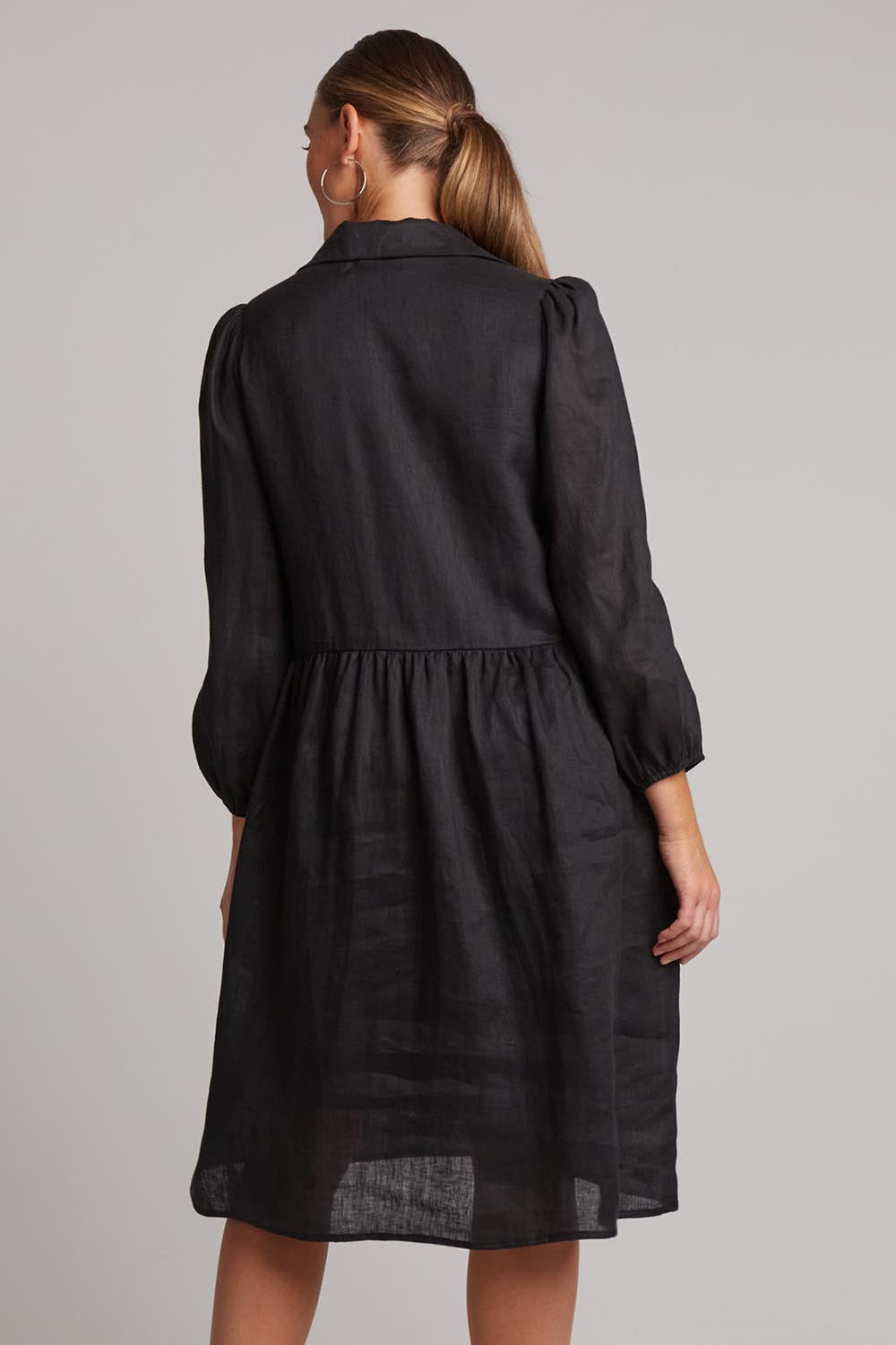 A model wearing the Studio Linen Midi Shirt Dress in colour Ebony (Black), from the back