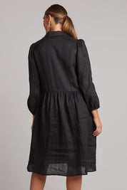 A model wearing the Studio Linen Midi Shirt Dress in colour Ebony (Black), from the back