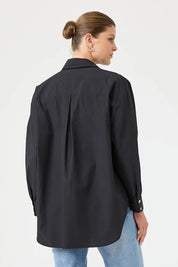 A model wearing the Studio Oversize Cotton Shirt in colour Ebony (Black), from the back