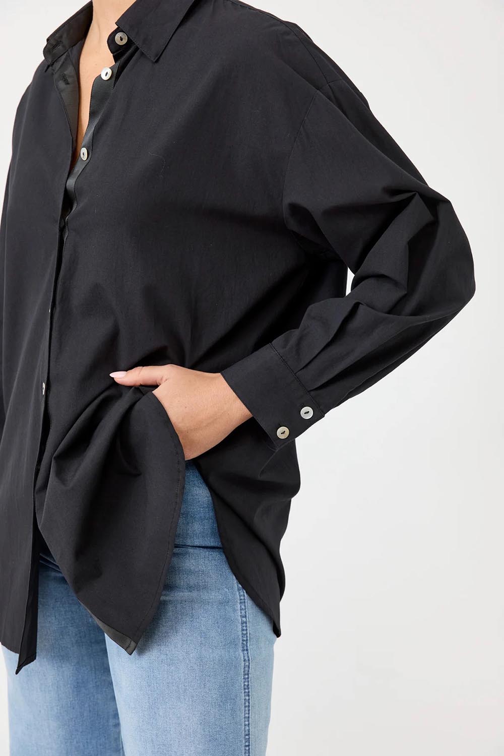 A model wearing the Studio Oversize Cotton Shirt in colour Ebony (Black), from the front, cropped image