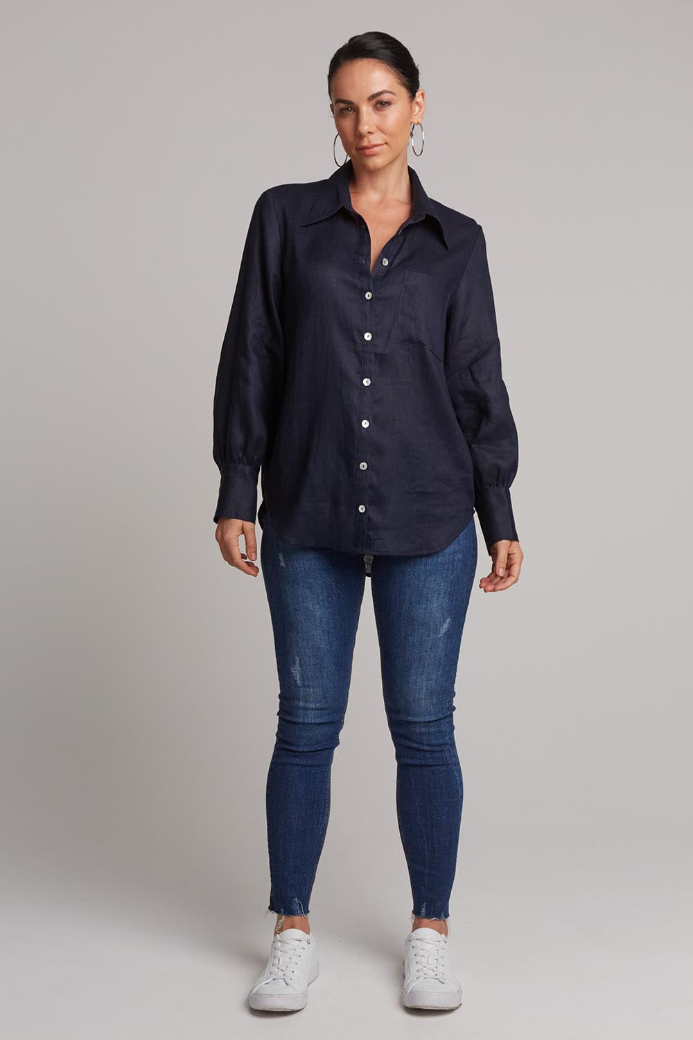 A model wearing the Studio Linen Shirt in colour Navy (Blue), from the front, showing the whole outfit