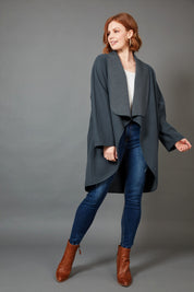 A model wearing the Klein Wrap Jacket in colour Oxford (Blue), from the front, showing the whole outfit