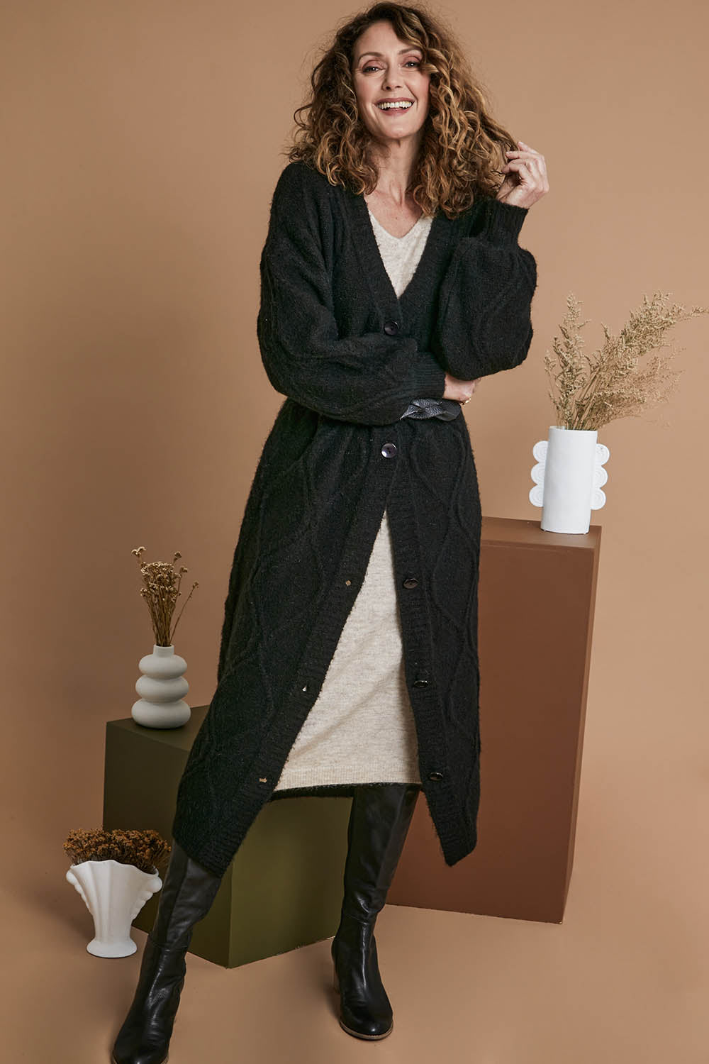 Model Emma wearing size OneSize of the Howie Cable Cardigan in colour Ebony (Black), from the front, showing the whole outfit