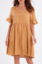 Model Madeline wearing size S of the La Vie Dress in colour Caramel, from the front, cropped image
