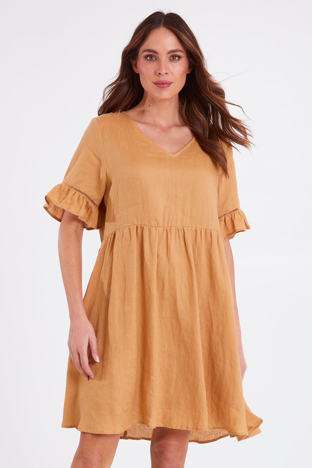 Model Madeline wearing size S of the La Vie Dress in colour Caramel, from the front, cropped image