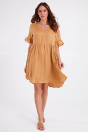 Model Madeline wearing size S of the La Vie Dress in colour Caramel, from the front, showing the whole outfit