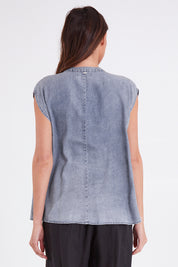 Model Madeline wearing size S of the Elan Top in colour Denim (Blue), from the back