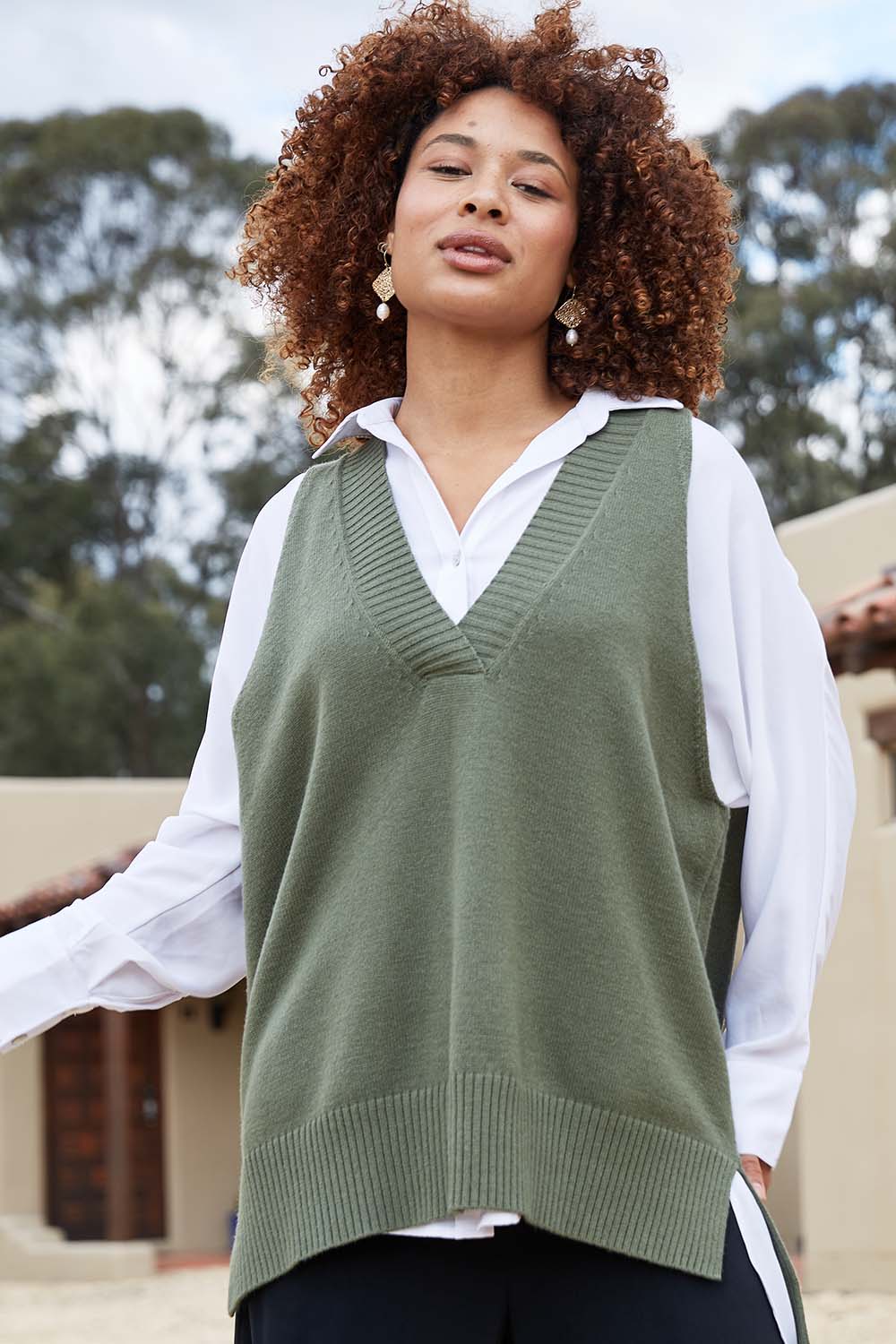 A model wearing the Nakako Vest in colour Moss (Green), from the front, showing the whole outfit