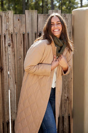 A model wearing the Ribe Coat in colour Putty, from the front, showing the whole outfit
