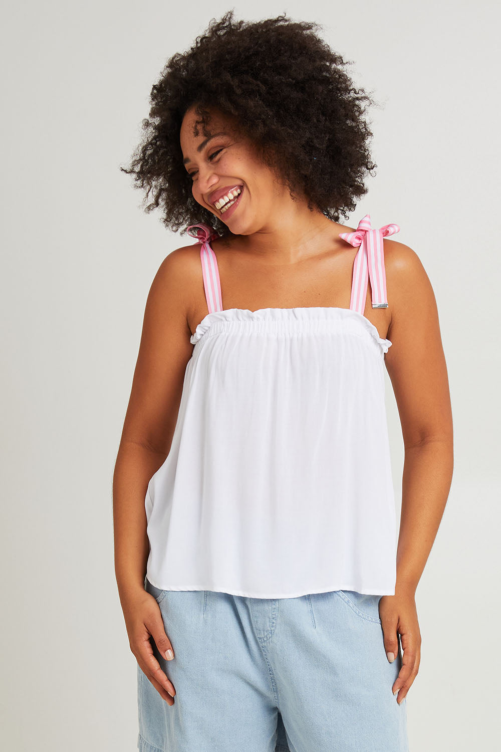 Model Olivia wearing size S of the La Mer Tie Tank in colour Opal (White), from the front, cropped image