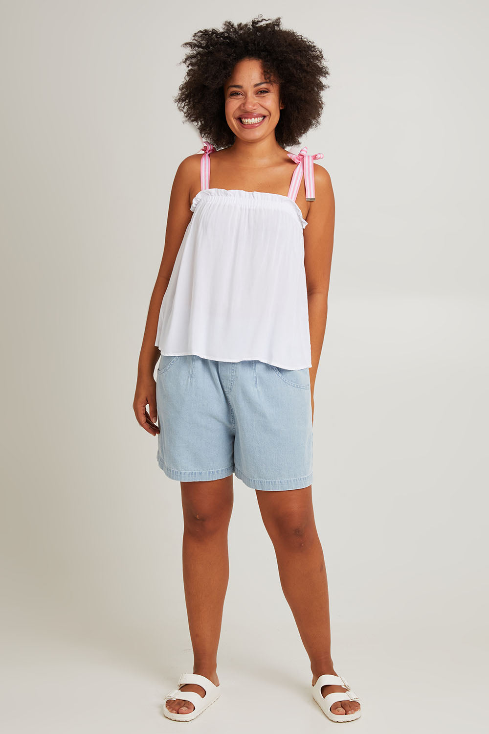 Model Olivia wearing size S of the La Mer Tie Tank in colour Opal (White), from the front, showing the whole outfit