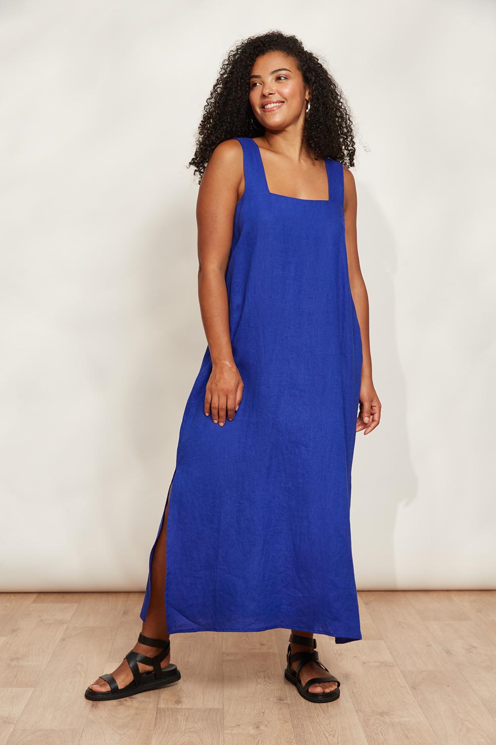 A model wearing the Halcyon Linen Tank Dress in colour Cobalt (Blue), from the front, showing the whole outfit