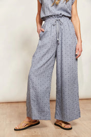 A model wearing the Zephyr Pant in colour Nevada (Blue), from the front, showing the whole outfit