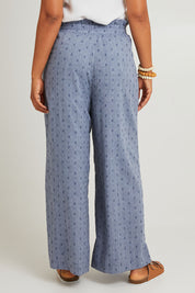 Model Olivia wearing size S of the Zephyr Pant in colour Nevada (Blue), from the back
