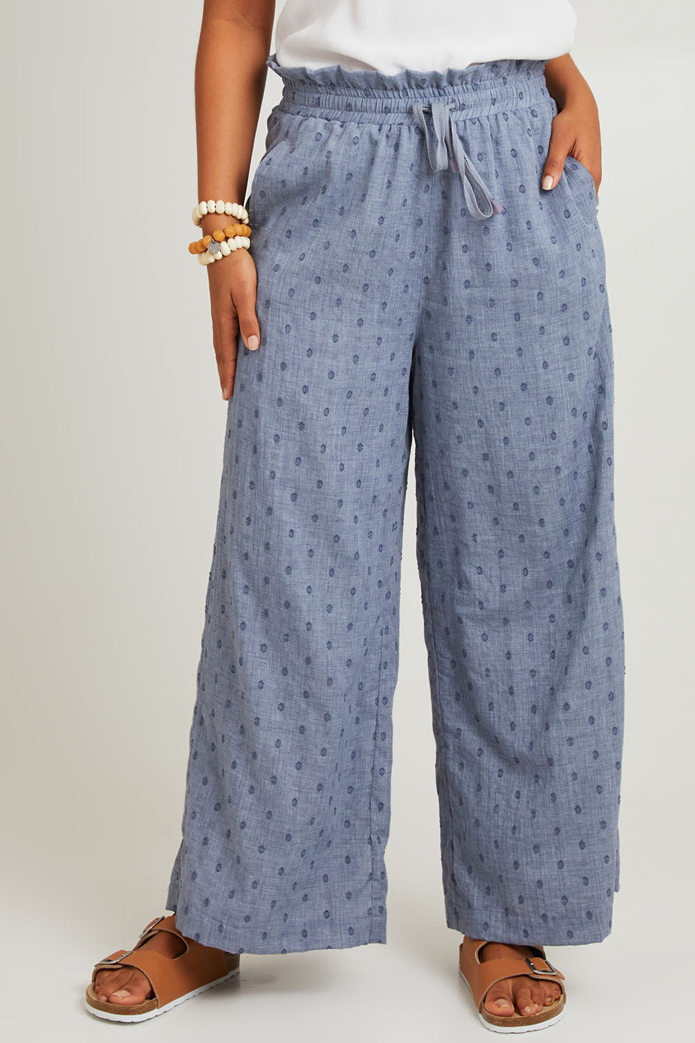 Model Olivia wearing size S of the Zephyr Pant in colour Nevada (Blue), from the front, cropped image
