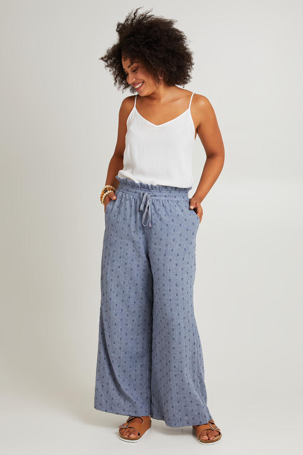 Model Olivia wearing size S of the Zephyr Pant in colour Nevada (Blue), from the front, showing the whole outfit