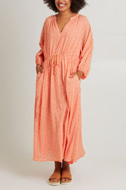 Model Olivia wearing size S of the Zephyr Maxi Dress in colour Papaya, from the front, cropped image