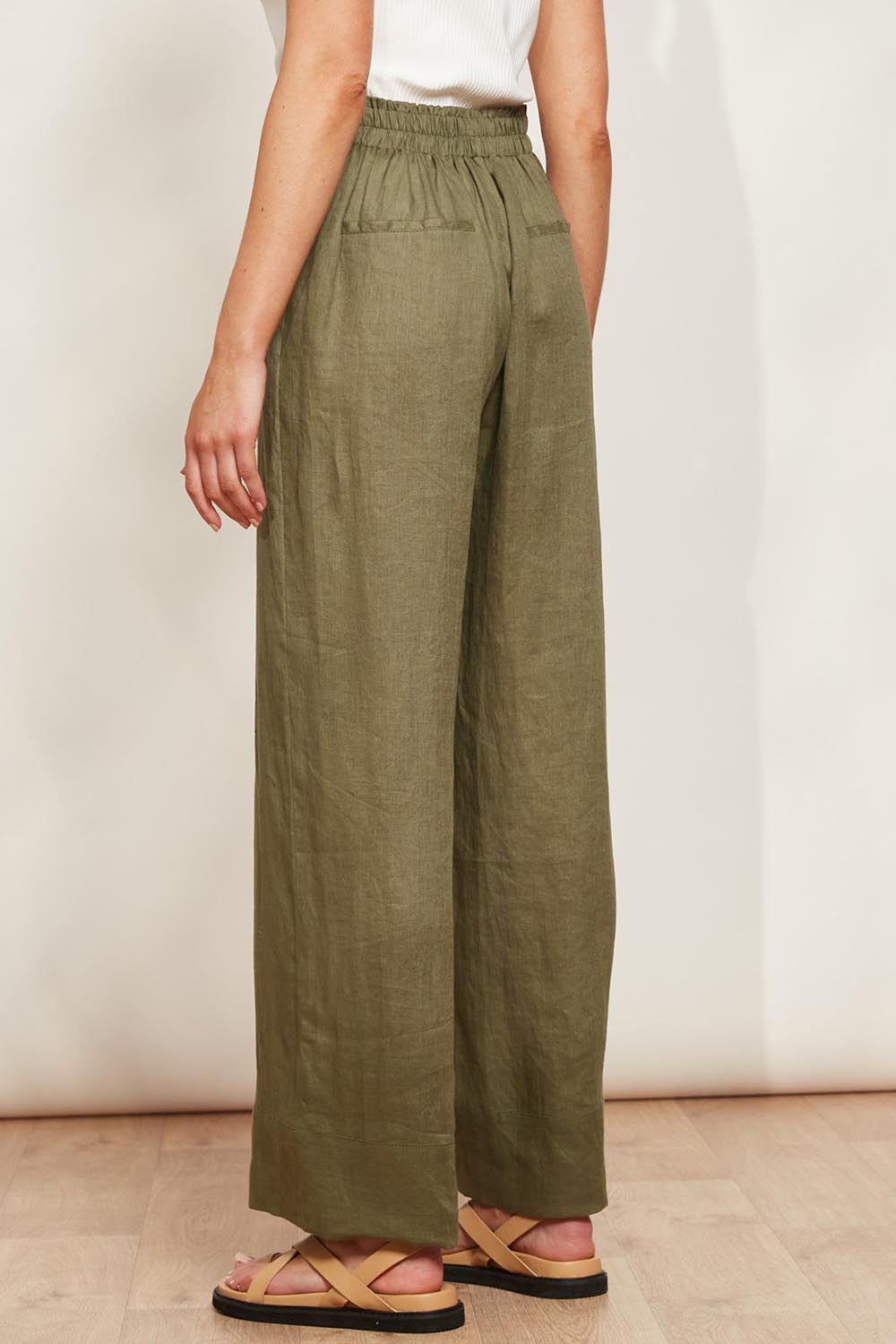 A model wearing the Studio Linen Pant in colour Khaki (Green), from the back