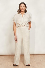 A model wearing the Studio Linen Pant in colour Tusk, from the front, showing the whole outfit