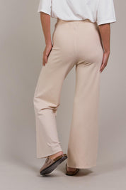 A model wearing the Palmer Knit Pant in colour Ecru, from the back