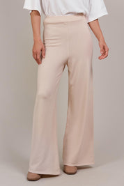 A model wearing the Palmer Knit Pant in colour Ecru, from the front, cropped image