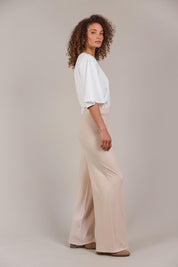 A model wearing the Palmer Knit Pant in colour Ecru, from the front, showing the whole outfit
