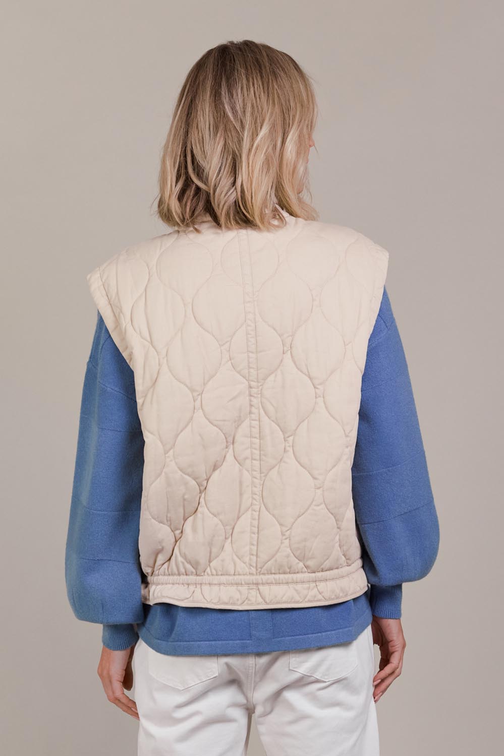 A model wearing the Pepi Cotton Vest in colour Ecru, from the back