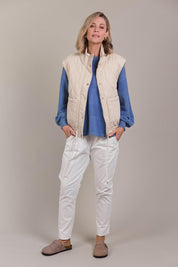 A model wearing the Pepi Cotton Vest in colour Ecru, from the front, showing the whole outfit